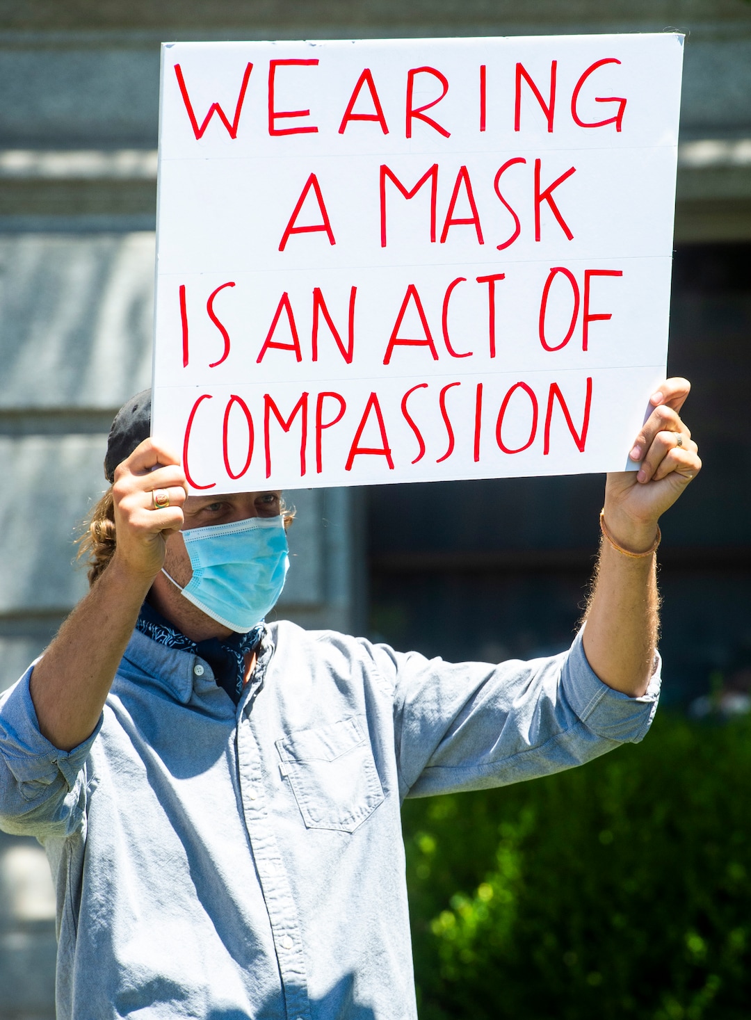 (Rick Egan  |  The Salt Lake Tribune)   Clark Goldsberry, a high school teacher at American Fork High School, wears a mask as a counter protester, during a rally protesting against masks being required in schools, before the Utah County Commission meeting in Provo, on Wednesday, July 15, 2020.