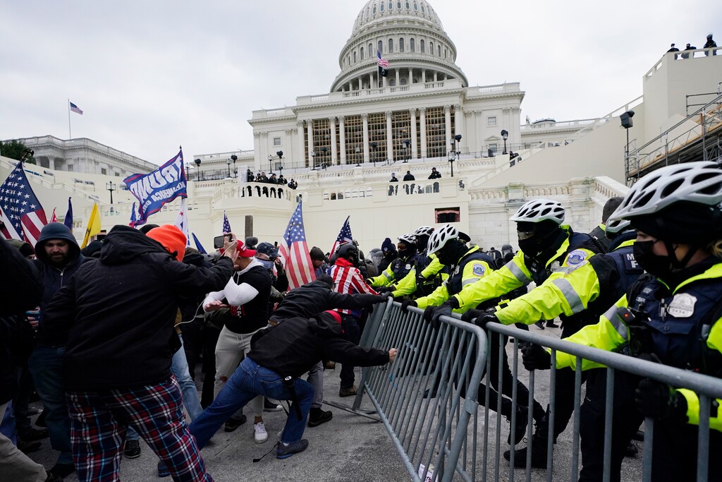 (Julio Cortez, AP file photo) In this Jan. 6, 2021, file photo, rioters try to break through a police barrier at the Capitol in Washington. The House voted to create a commission to investigate the storming of the Capitol.