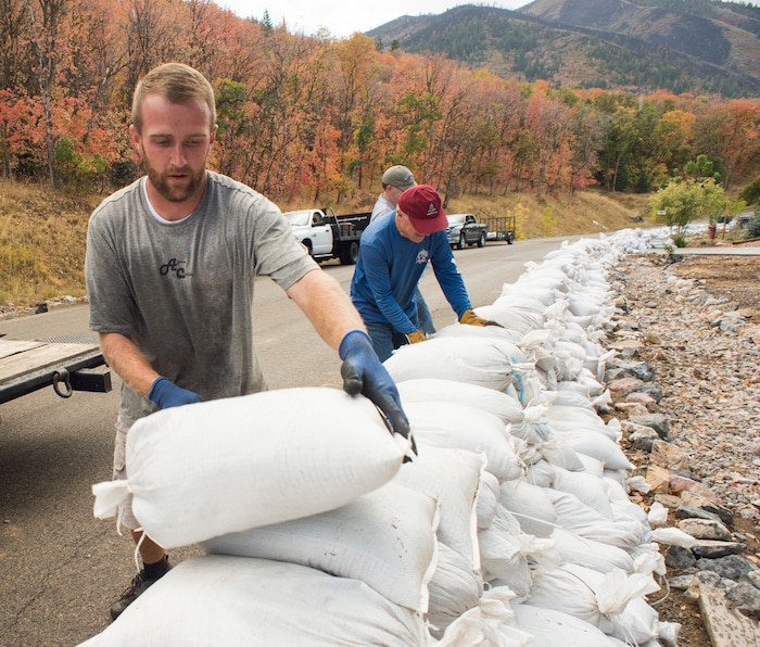 (Rick Egan  |  The Salt Lake Tribune)     Dallin Farley works alongside residents of Woodland Hills, stacking sand bags, incase there are flash floods with the coming rain, Monday, Oct. 1, 2018.


