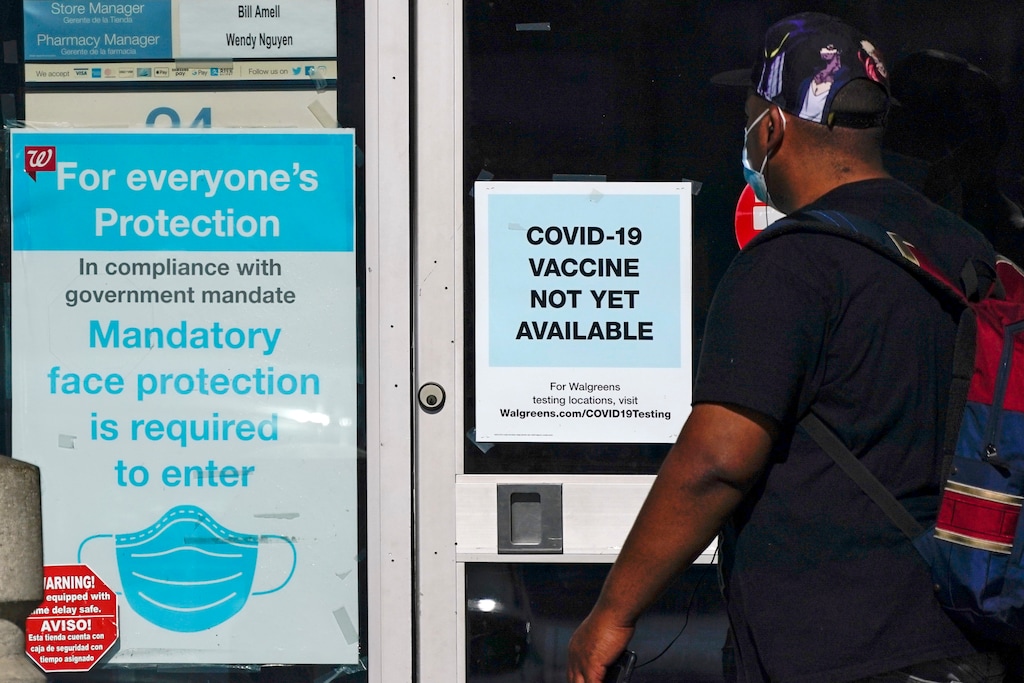 FILE - In this Dec. 2, 2020, file photo, a customer walks past a sign indicating that a COVID-19 vaccine is not yet available at Walgreens in Long Beach, Calif. (AP Photo/Ashley Landis, File)