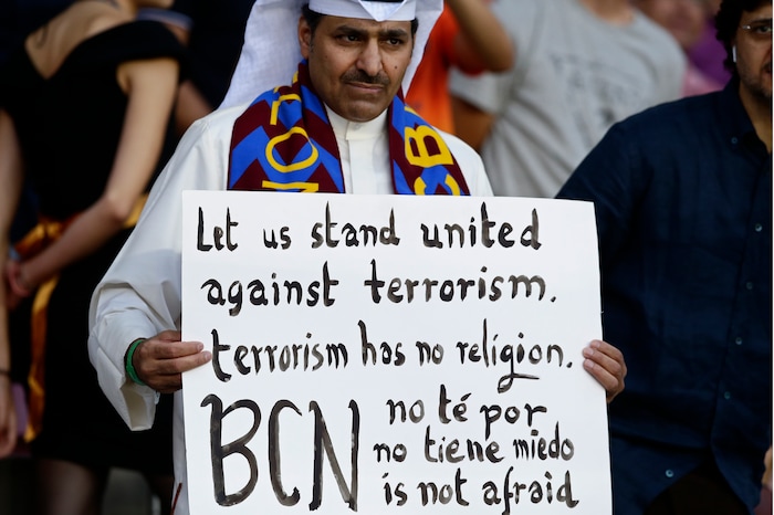 A Barcelona fan holds a sign against terrorism and in support of the victims of the van attacks before a La Liga soccer match between Barcelona and Betis at the Camp Nou stadium in Barcelona, Spain, Sunday, Aug. 20, 2017. Words at bottom in Catalan, Spanish and English read 'Barcelona is not afraid'. Security was stepped up for the match after a terror attack that killed 14 people and wounded over 120 in Barcelona and police put up scores of roadblocks across northeast Spain on Sunday in hopes of capturing a fugitive suspect at large following the vehicle attack. (AP Photo/Manu Fernandez)
