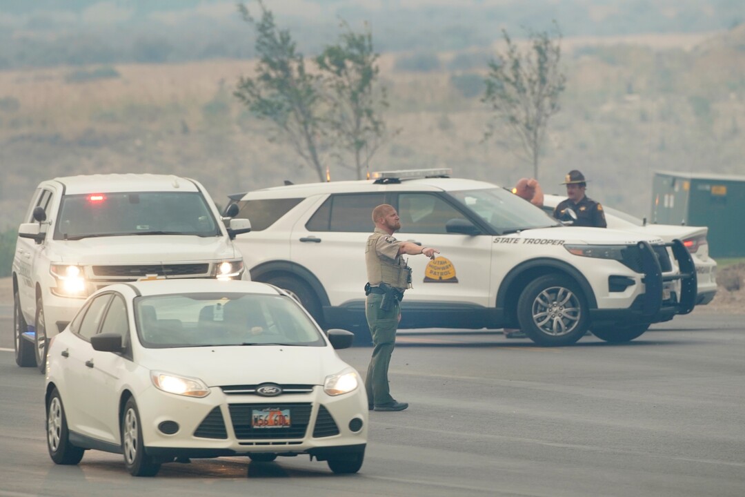 An officer directs traffic as people are evacuated from their homes in south Saratoga Springs due to a wildfire on June 28, 2020. Photo by George Frey.