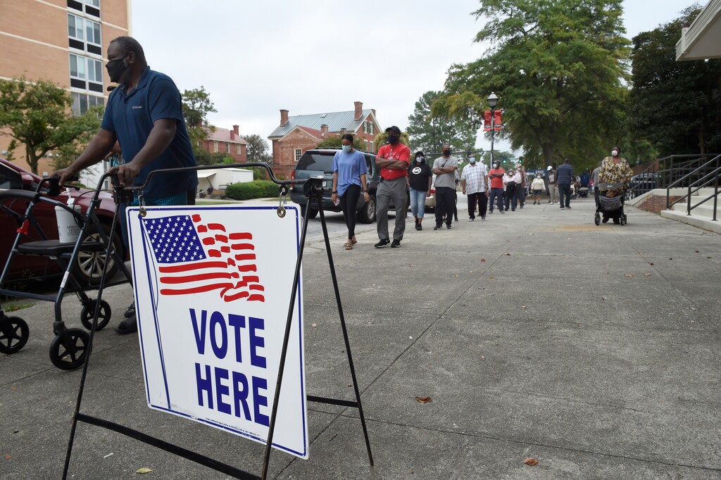 FILE -In this Oct. 12, 2020 file photo, voters wait in line to cast their ballot during early voting at the Bell Auditorium in Augusta, Ga. Fueled by Black turnout, Democrats scored stunning wins in the once reliably red state for president and U.S. Senate in the last election cycle. Republican lawmakers are now forging ahead with an aggressive slate of voting legislation that critics argue is tailored toward curtailing the power of Black voters. (Michael Holahan/The Augusta Chronicle via AP, File)
