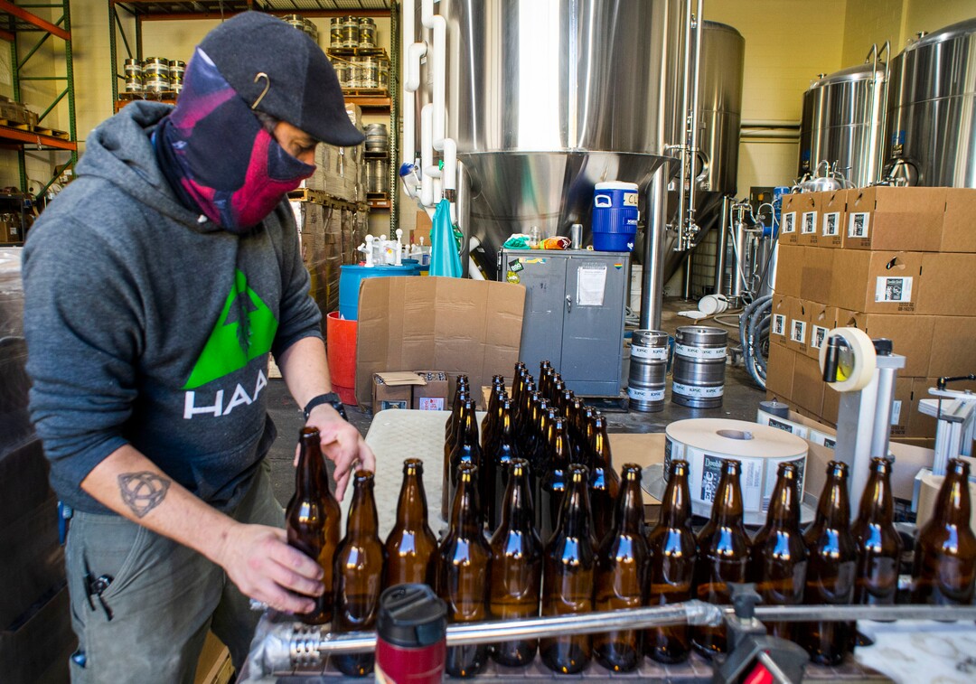 (Rick Egan  |  The Salt Lake Tribune)    Aaron Buckner loads bottles on the conveyer belt, Epic Brewing Co. in Salt Lake City, Thursday, Oct. 29, 2020.