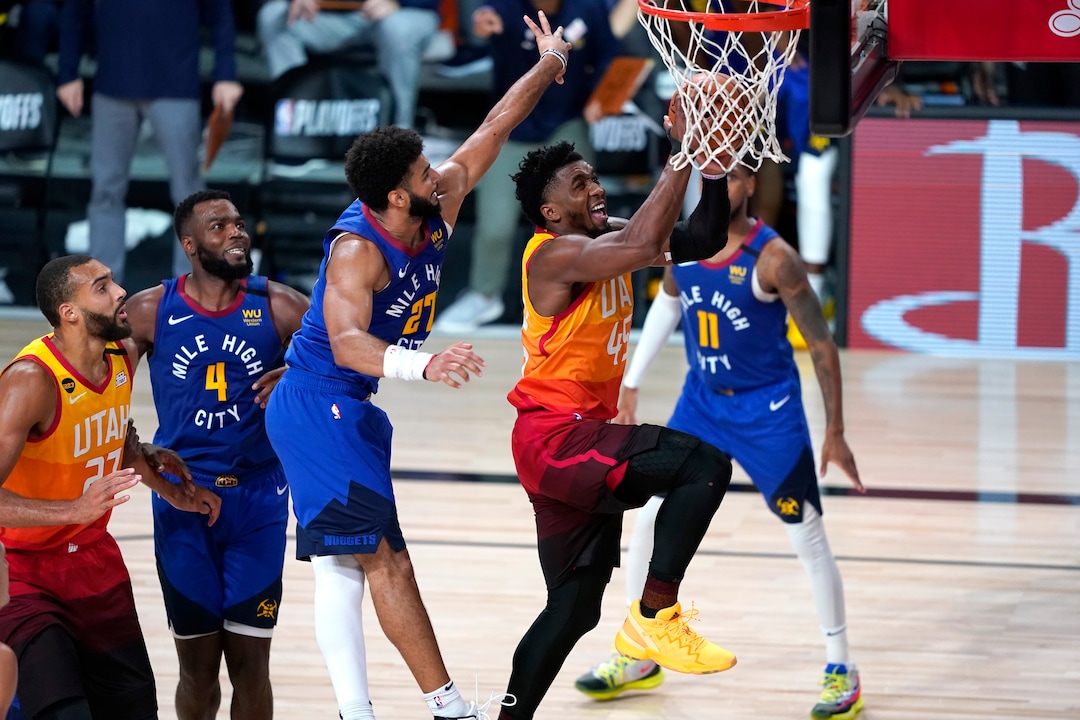 Utah Jazz's Donovan Mitchell (45) goes up for a shot as Denver Nuggets' Jamal Murray (27) defends during the second half of an NBA basketball first round playoff game Sunday, Aug. 23, 2020, in Lake Buena Vista, Fla. (AP Photo/Ashley Landis, Pool)