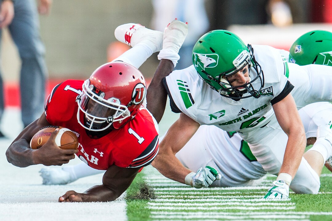 (Chris Detrick  |  The Salt Lake Tribune)  Utah Utes quarterback Tyler Huntley (1) is tackled by North Dakota Fighting Hawks defensive back Evan Holm (6) during the game at Rice-Eccles Stadium Thursday, August 31, 2017. Utah Utes are leading North Dakota Fighting Hawks 17-9 at halftime. 