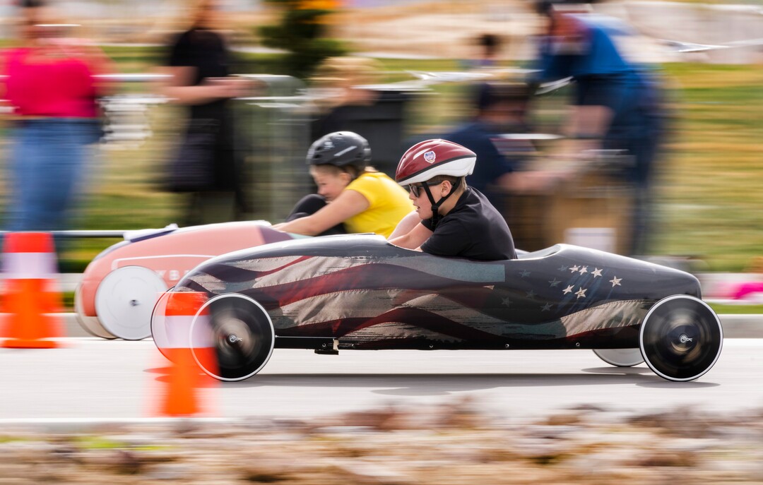(Rick Egan | The Salt Lake Tribune) GoBe Realty leads the Titanium Night Car on a race during the Daybreak Soap Box Derby, on Saturday, April 24, 2021.