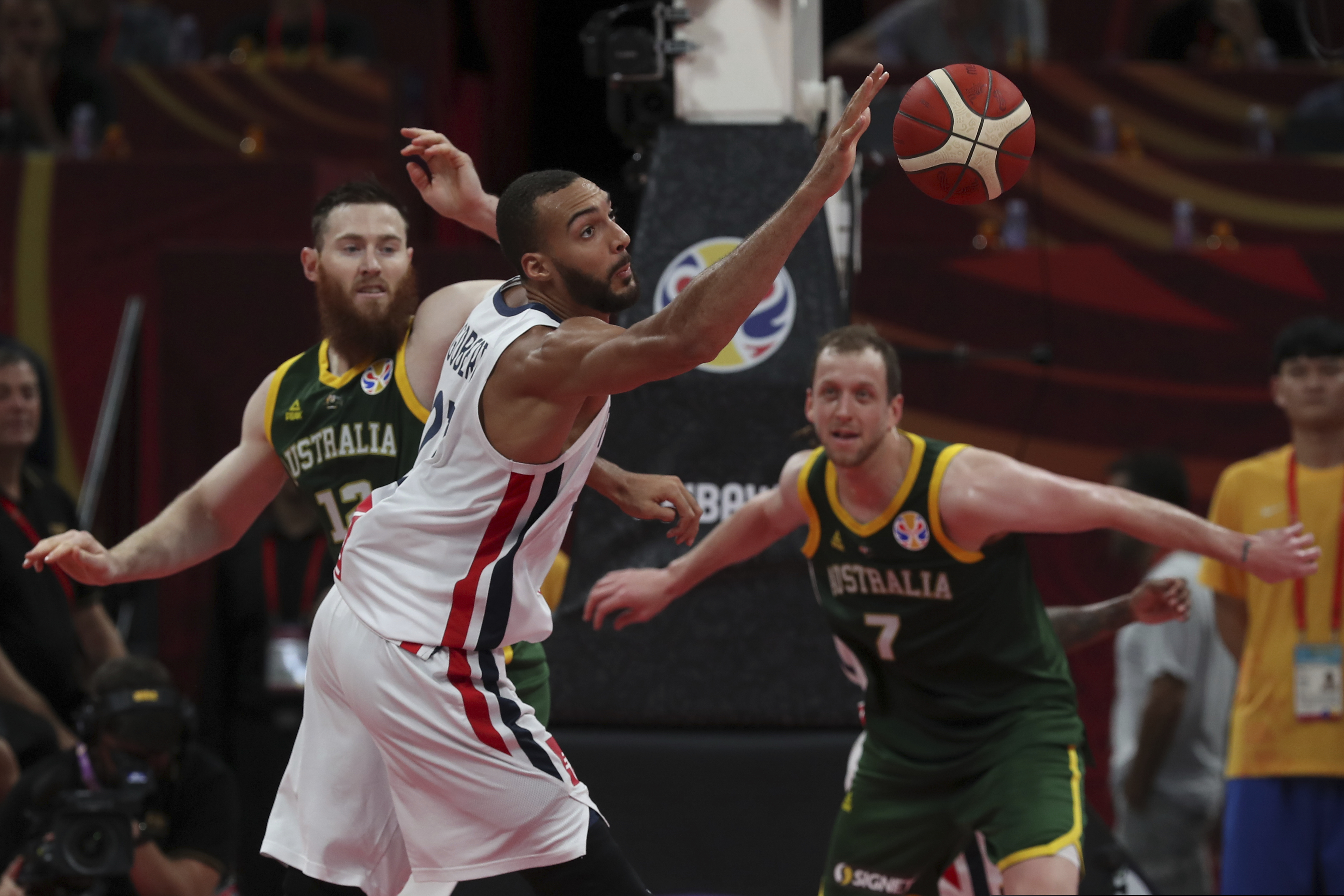 (Ng Han Guan | The Associated Press) Rudy Gobert of France reaches for the ball over Aron Baynes, left, and Joe Ingles, right, of Australia during their third placing match for the FIBA Basketball World Cup at the Cadillac Arena in Beijing, Sunday, Sept. 15, 2019.