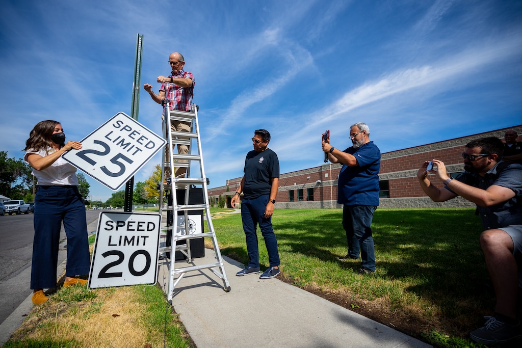 (Trent Nelson  |  The Salt Lake Tribune) Mayor Erin Mendenhall and council member Dan Dugan swap out a 25 mph speed limit sign for a new 20 mph sign in Salt Lake City on Wednesday, July 27, 2022.