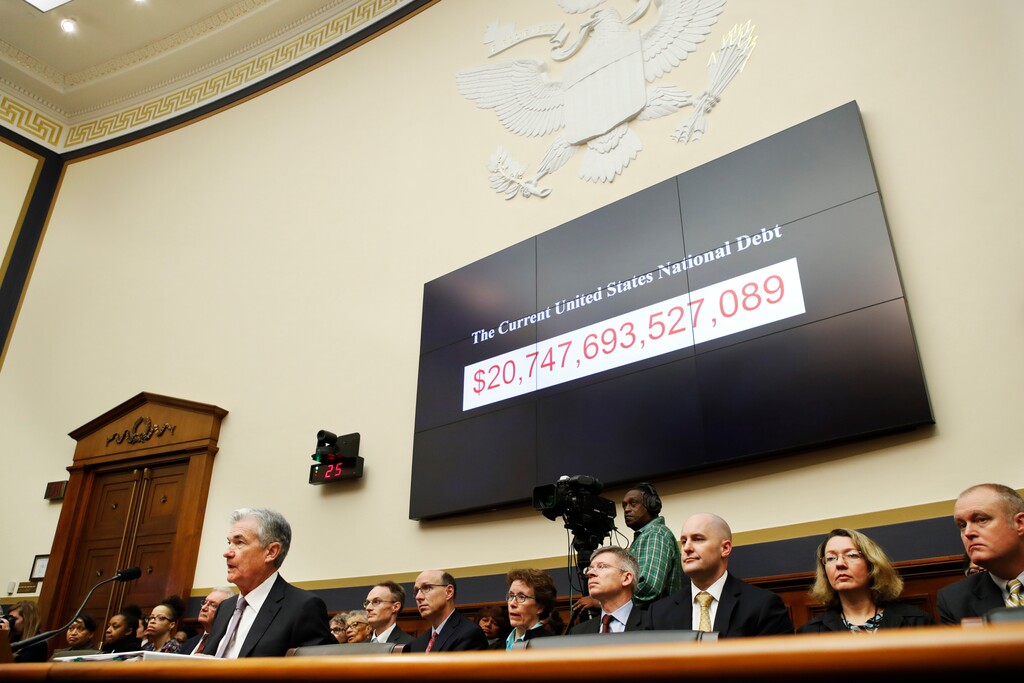 The National debt is shown behind Federal Reserve Chairman Jerome Powell, left, as he makes the semiannual monetary policy report to the House Financial Services Committee, Tuesday, Feb. 27, 2018, in Washington. (AP Photo/Jacquelyn Martin)