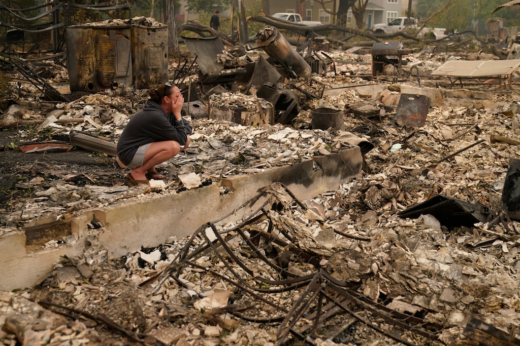 (John Locher | AP file photo)  In this Sept. 11 photo, Desiree Pierce cries as she visits her home destroyed by the Almeda Fire in Talent, Ore. "I just needed to see it, to get some closure," said Pierce.