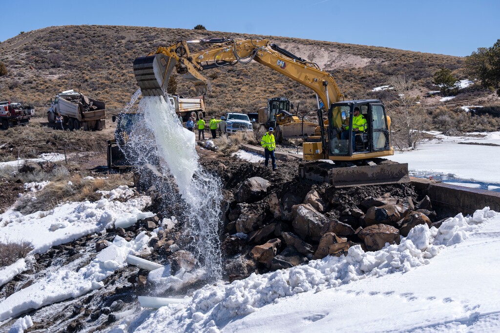 (Rick Egan | The Salt Lake Tribune) Workers scoop chunks of ice out of Panguitch Lake to relieve pressure on the reservoirs dam on Thursday, April 11, 2024.