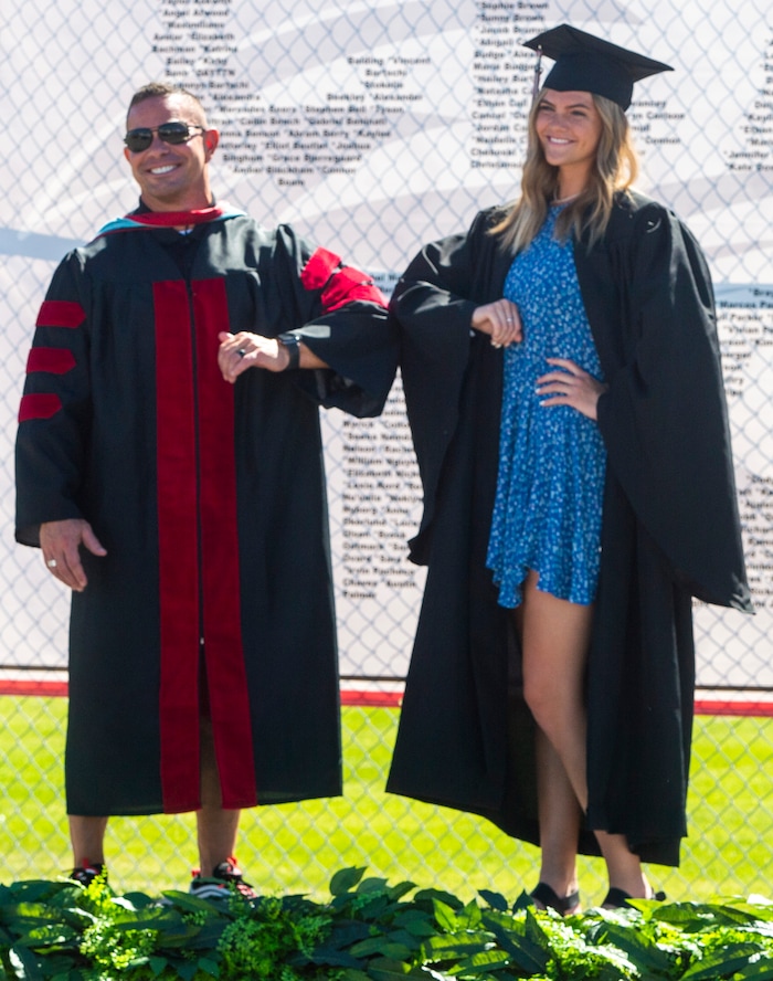 (Rick Egan  |  The Salt Lake Tribune)     Alta High principal, Brian McGill bumps elbows with Kate Dowdell during the parade of 2020 graduates, in a “drive through” graduation ceremony at Alta High, Thursday, May 28, 2020.