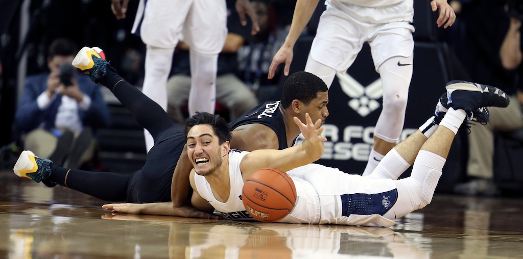 San Diego State's Matt Mitchell, left, and Utah State's Abel Porter dive for a loose ball during the first half of an NCAA college basketball game in the Mountain West Conference men's tournament championship Saturday, March 16, 2019, in Las Vegas. (AP Photo/Isaac Brekken)