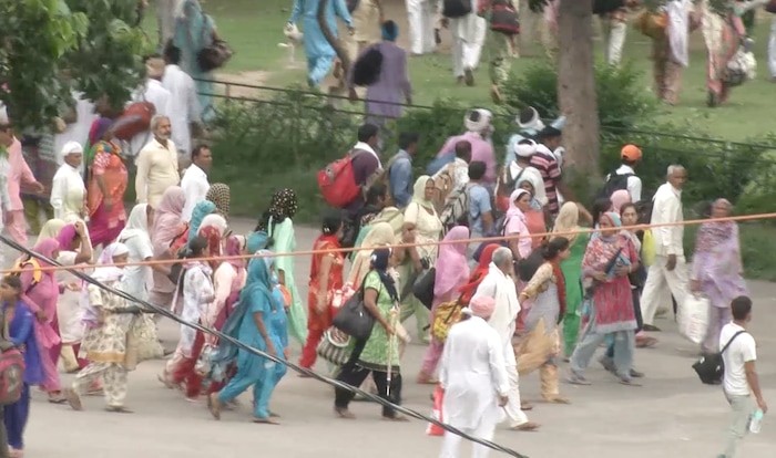 In this image made from video, supporters of an Indian guru who calls himself Saint Dr. Gurmeet Ram Rahim Singh Ji Insaan walk on the street as they react after his verdict was announced in Panchkula, India, Friday, Aug. 25, 2017. A north Indian court convicted the flamboyant leader of a quasi-religious sect of raping two of his followers, prompting thousands of supporters to shout angry protests and attack journalists covering Friday's verdict. (AP Photo)