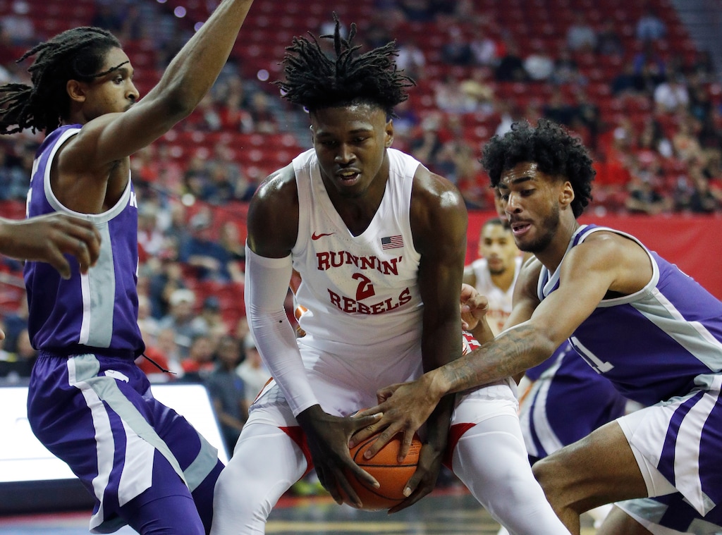 UNLV's Donnie Tillman, center, drives through Kansas State's Cartier Diarra, left, and Antonio Gordon during the first half of an NCAA college basketball game, Saturday, Nov. 9, 2019, in Las Vegas. (AP Photo/John Locher)