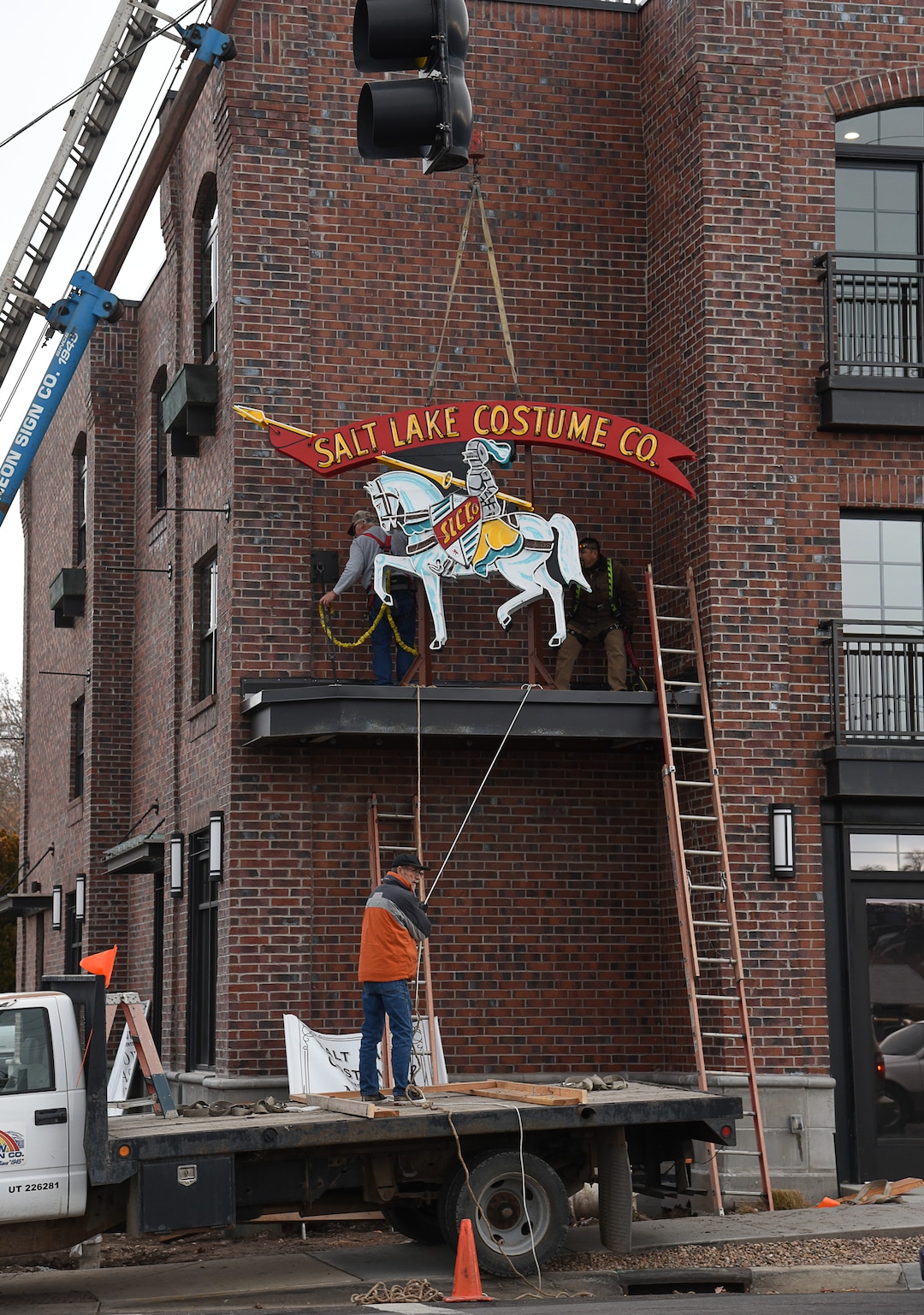 (Francisco Kjolseth  |  The Salt Lake Tribune)  The Salt Lake Costume Co. sign, originally designed by Lloyd S. Coley in the '50s while working for Rainbow Neon Sign Co., lives on once more as crews install it back home in its original location at 1700 S. 1100 East on Monday, Dec. 23, 2019, in what is now called the Salt Lake Costume Apartments.