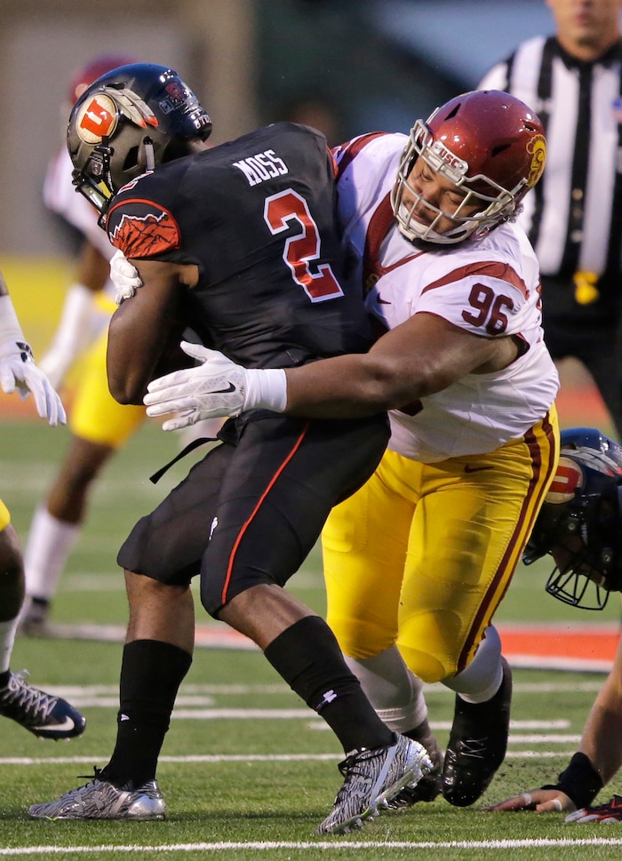 Southern California defensive tackle Stevie Tu'ikolovatu (96) tackles Utah running back Zack Moss (2) in the first half during an NCAA college football game Friday, Sept. 23, 2016, in Salt Lake City.  (AP Photo/Rick Bowmer) 