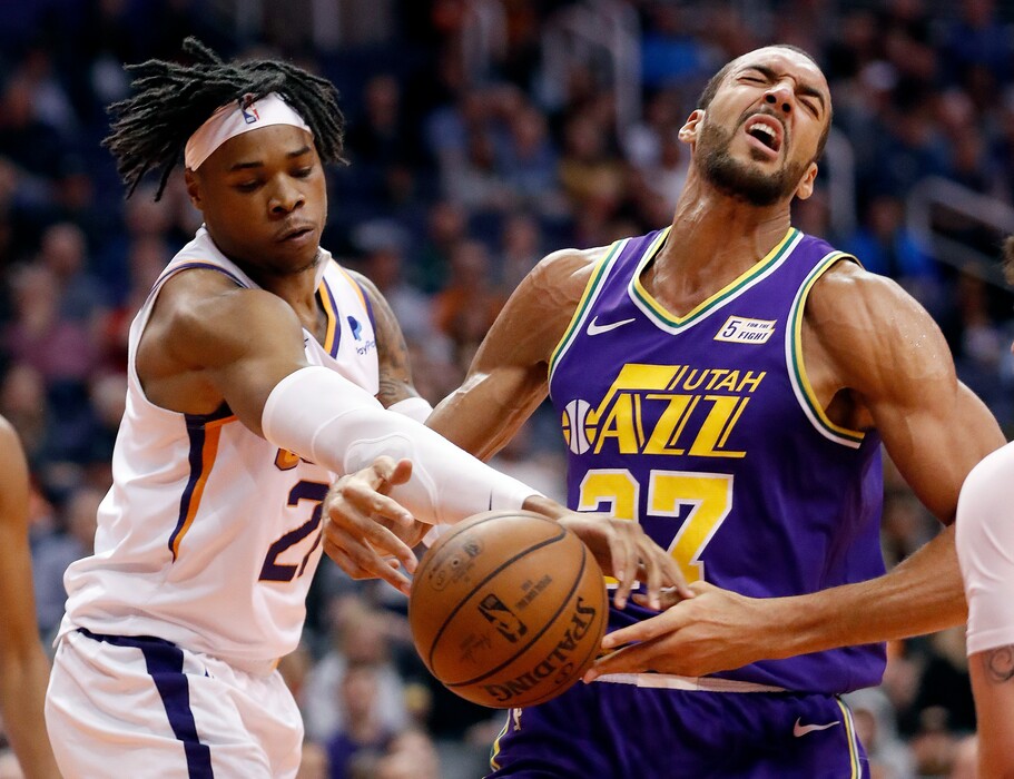 Phoenix Suns forward Richaun Holmes, left, fouls Utah Jazz center Rudy Gobert during the first half of an NBA basketball game Wednesday, March 13, 2019, in Phoenix. (AP Photo/Matt York)