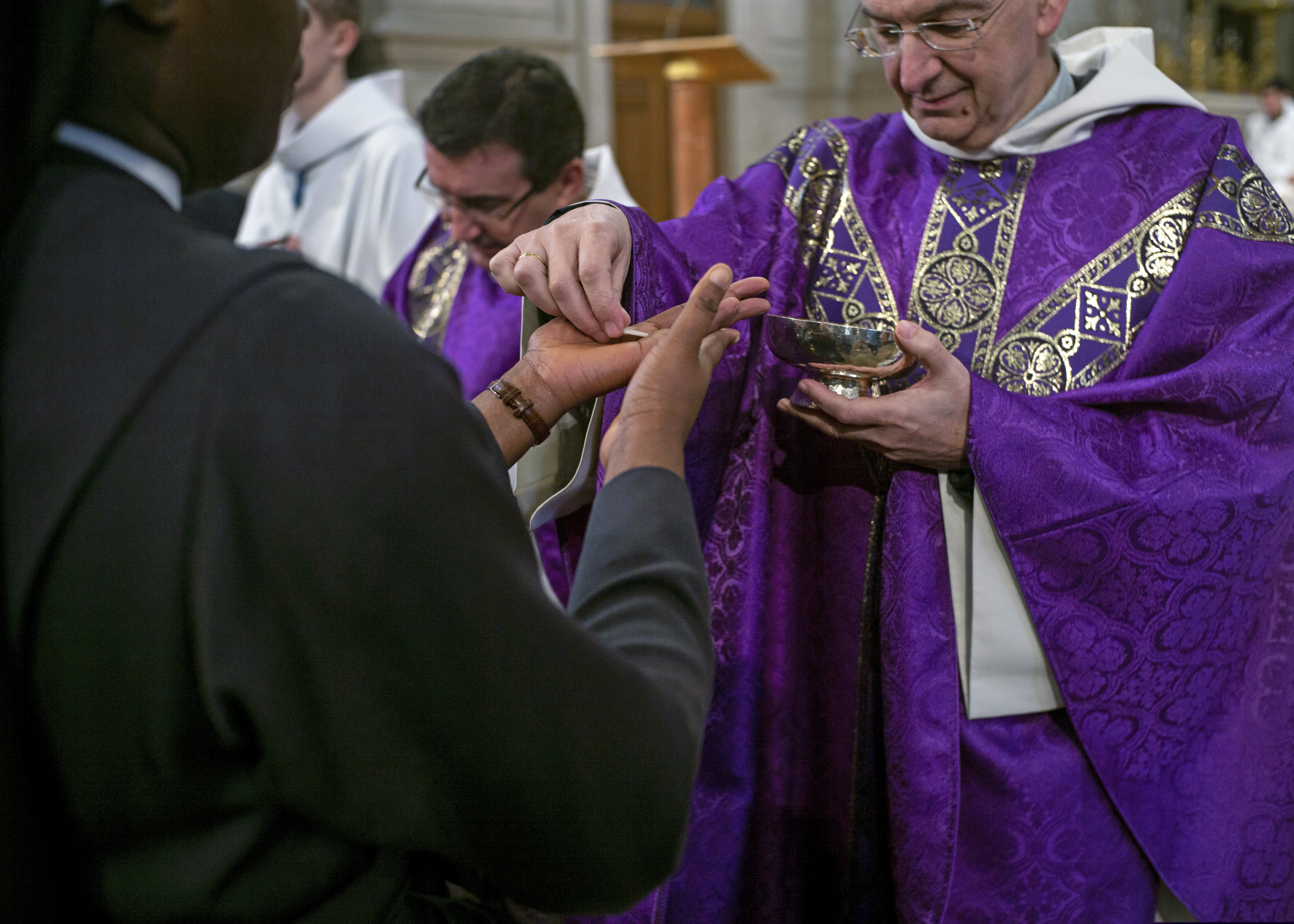 (Rafael Yaghobzadeh | The Associated Press) Faithful receive Holy Communion into their hands during a Mass celebrated at St. Francois Xavier Church in Paris, France, Sunday, March 1, 2020. The archbishop of Paris is asking all of the French capital's parish priests to change the way they administer Communion to counter the spread of the coronavirus.