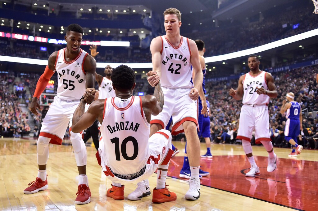 Toronto Raptors guard Delon Wright (55) and center Jakob Poeltl (42) help up guard DeMar DeRozan after he was knocked down and fouled while making a basket during a game against the Philadelphia 76ers in Toronto earlier this season. (Frank Gunn/The Canadian Press via AP)