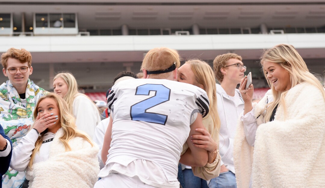 (Leah Hogsten  |  The Salt Lake Tribune) Sky ViewÕs quarterback Kason Carlsen climbs into the stands for a kiss after the win with the team. Sky View High School defeated Park City 35-0 to win the 4A State Championship football title, Nov. 11, 2019 at Rice-Eccles Stadium.