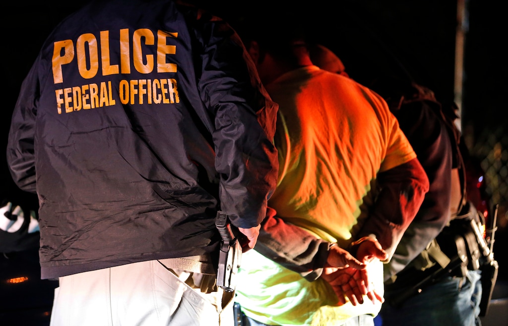 (Steve Helber | AP file photo)  U.S. Immigration and Customs Enforcement agents detain a person during a raid in Richmond, Va., on Oct. 22, 2018.