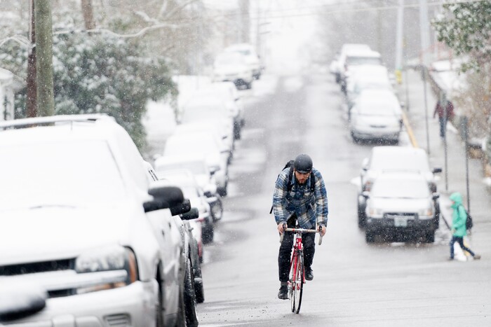 UT senior Marlow Payat, of Memphis, bikes along Laurel Ave during an afternoon snowfall in Knoxville, Tenn., on Tuesday, Jan. 16, 2018. (Calvin Mattheis/Knoxville News Sentinel via AP)