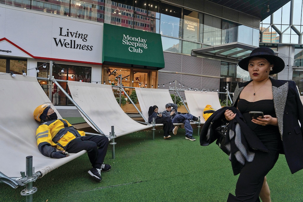 A delivery man takes a nap near life style shops in Beijing, Tuesday, Nov. 11, 2025. (AP Photo/Ng Han Guan)
