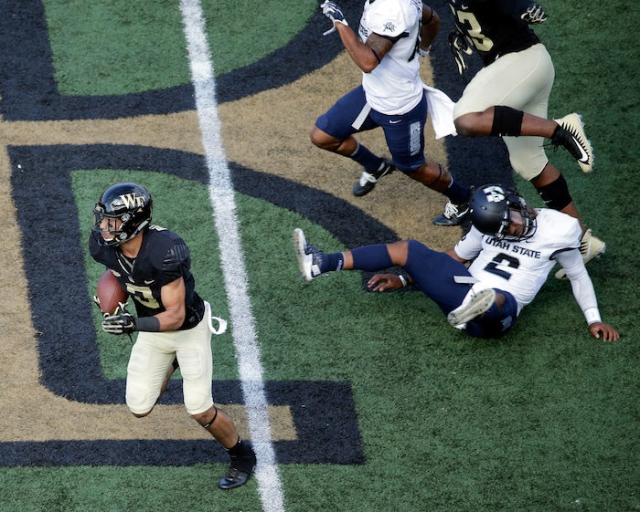 Wake Forest's Jessie Bates III (3) returns a punt past Utah State's Kent Myers (2) in the second half of an NCAA college football game in Winston-Salem, N.C., Saturday, Sept. 16, 2017. Myers was injured on the play. (AP Photo/Chuck Burton)