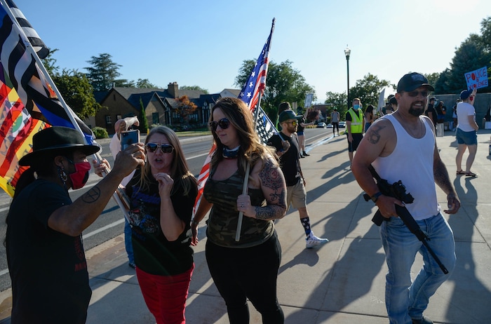(Francisco Kjolseth  |  The Salt Lake Tribune) A couple women with the so-called “Patriots Prepared” wave flags as they show up in support of law enforcement along with a handful of armed men saying “we don’t want people destroying our shit,” as part of national day of protest against police crimes, the National Alliance Against Racist and Political Repression, the Salt Lake Civilian Police Accountability Council and other groups gather at the Utah Capitol on Saturday, July 18, 2020.