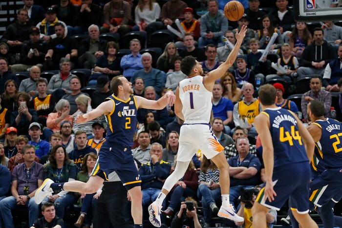 Phoenix Suns guard Devin Booker (1) lays up the ball as Utah Jazz guard Joe Ingles (2) defends in the first half during an NBA basketball game Monday, Feb. 24, 2020, in Salt Lake City. (AP Photo/Rick Bowmer)