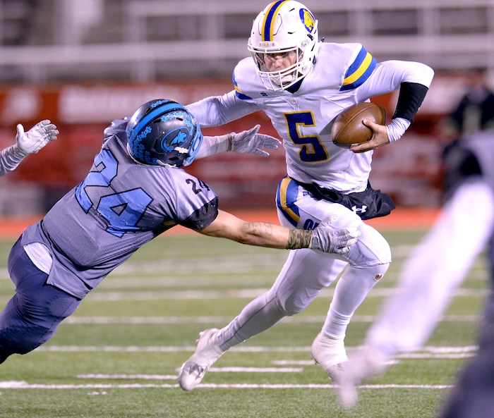 (Leah Hogsten  |  The Salt Lake Tribune)  Orem's quarterback Cooper Legas slips past Sky View's Ryder Lundahl on a first down run. Orem High School defeated Sky View High School 28-12 during their class 4A state semifinal game at Rice-Eccles Stadium, Friday, Nov. 10, 2017.