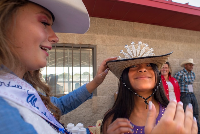 (Rick Egan  |  The Salt Lake Tribune)    Lauren Denbleyker, 11, from South Jordan gets a hat from 2nd attendant, Reagann McCurdy, at the West Jordan Western Stampede Rodeo, Saturday, July 6, 2019.