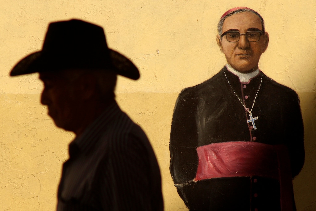 (Salvador Melendez | AP file photo) In this Saturday, March 24, 2018, photo, a man walks past a mural depicting the late Archbishop Oscar Arnulfo Romero on an exterior wall of the Metropolitan Cathedral where a Mass was offered to mark the anniversary of the archbishop's death, in San Salvador, El Salvador. Pope Francis has moved the Rev. Rutilio Grande, a Jesuit priest who inspired St. Oscar Romero and was himself a victim of El Salvador's right-wing death squads, a step closer to possible sainthood. Francis approved a decree Friday, Feb. 21, 2020, proclaiming Grande a martyr for the Catholic faith.