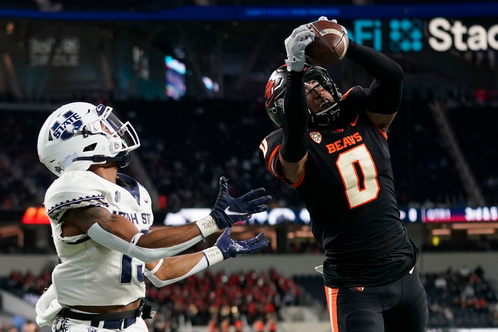 (Ashley Landis | AP) Oregon State defensive back Akili Arnold (0) catches an interception in the end zone during the first half of the LA Bowl NCAA college football game against Utah State in Inglewood, Calif., Saturday, Dec. 18, 2021. The pass was intended for Utah State wide receiver Deven Thompkins, left.