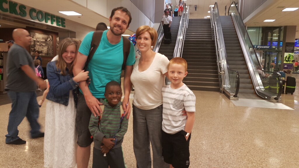 (Courtesy of the Palmer family) Josh and Lisa Palmer stand with their children in the Salt Lake International Airport after adopting their youngest son Robert (middle) from Ghana in July 2015.