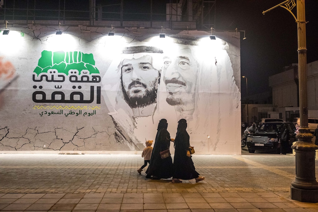 (Iman Al-Dabbagh | New York Times file photo)  Women walk by a poster about Saudi National Day in Riyadh, Saudi Arabia in December 2019.