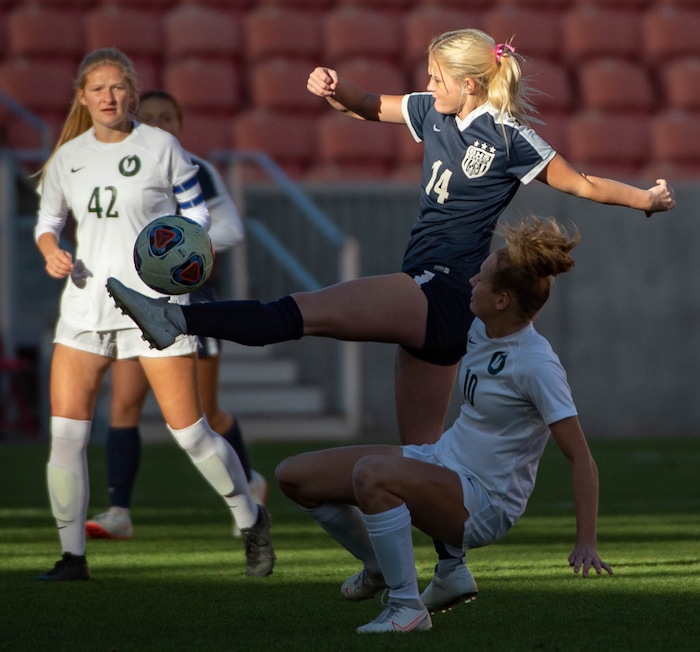 (Francisco Kjolseth  |  The Salt Lake Tribune) Madeline Callahan #14 of Bonneville reaches out for control of the ball over Kelly Bullock #10 of Olympus as they compete in their 5A high school girls championship game at Rio Tinto Stadium in Sandy on Friday, Oct. 23, 2020. Bonneville went on to win 1-0 in overtime.