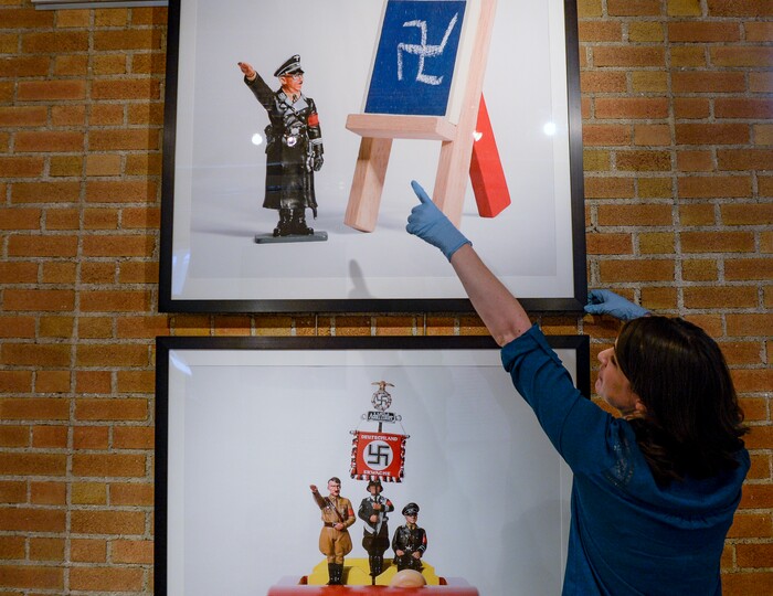 Leah Hogsten  |  The Salt Lake Tribune Ogden Union Station Museum director Holly Andrew positions the color photographs of Jim Riswold's "The Hitlermobile," 2005 at the exhibit, "Speaking Volumes: Transforming Hate," opening Friday, June 15 at the Ogden Union Station Museum. The exhibit showcases 30 artists who transformed white-supremacist books into uplifting works of art.