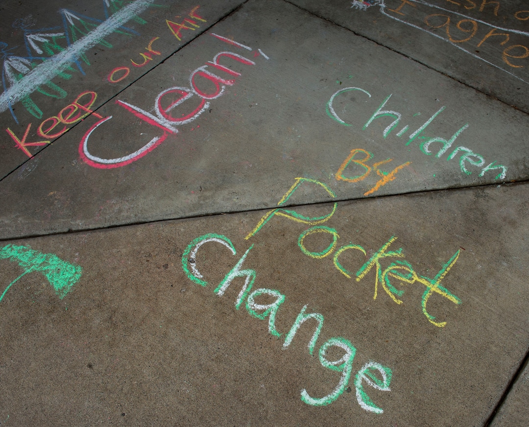 (Rick Egan  |  The Salt Lake Tribune)   Carolyn Hoffert and Angie Parkin and their kids draw chalk art on the sidewalk at Lehi City Hall to protest the expansion of Geneva Rock's mining activities near their neighborhood, Tuesday, April 2, 2019.