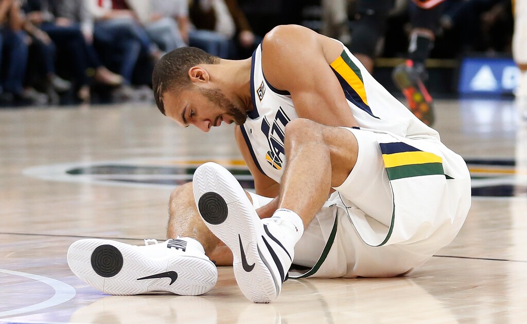 Utah Jazz center Rudy Gobert grabs his knee after being injured in the second half during an NBA basketball game against the Miami Heat, Friday, Nov. 10, 2017, in Salt Lake City. (AP Photo/Rick Bowmer)