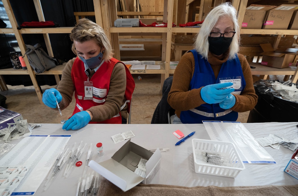 (Francisco Kjolseth  | The Salt Lake Tribune) Nurse Sarah Wilson, left, and Dr. Christina Richards fill syringes with the Moderna vaccine for those lining up to get the vaccine on Thursday, March 18, 2021, as part of a drive up at the Utah Film Studios in Park City.
