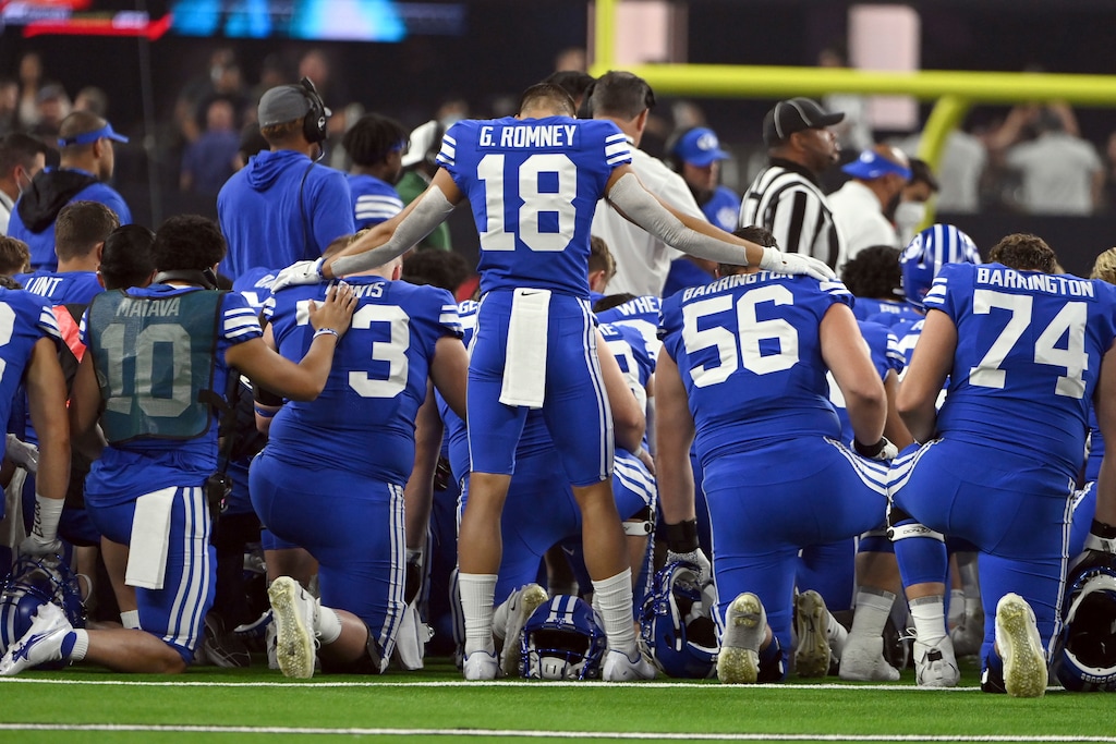 (David Becker | AP) BYU wide receiver Gunner Romney (18) stands over his teammates during an injury timeout in the first half of an NCAA college football game against Arizona Saturday, Sept. 4, 2021, in Las Vegas.