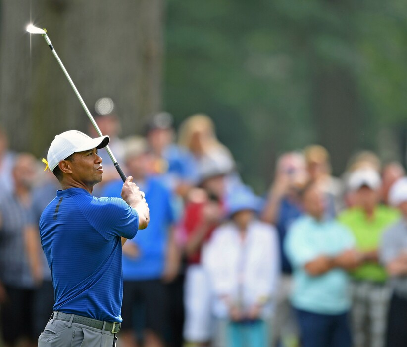 Tiger Woods follows through on his approach shot on the 10th hole during the first round of the Bridgestone Invitational golf tournament at Firestone Country Club, Thursday, Aug. 2, 2018, in Akron, Ohio. (AP Photo/David Dermer)