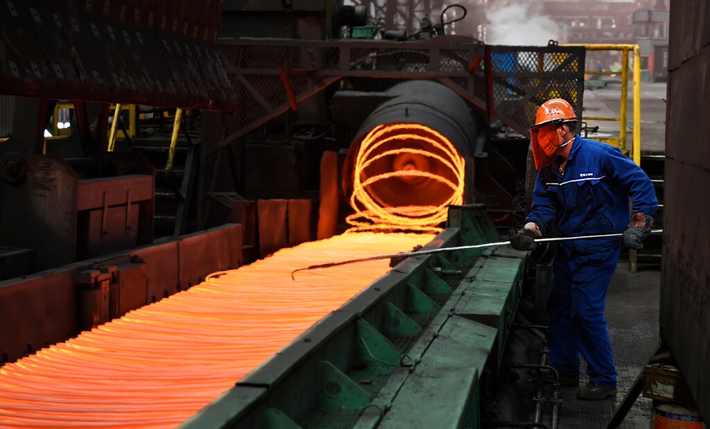 In this March 5, 2018 photo, a worker manipulates coils of steel at Xiwang Special Steel in Zouping County in eastern China's Shandong province. China says it "firmly opposes" U.S. President Donald Trump's tariff increase for imported steel and aluminum but gave no indication whether Beijing might impose its own measures in response. (Chinatopix via AP)