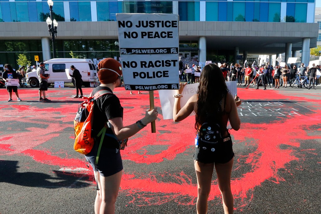 FILE - In this July 9, 2020, file photo, protesters gather in front of district attorney's office in Salt Lake City. Some Black Lives Matter protesters in Utah could face up to life in prison if they're convicted of splashing red paint and smashing windows during a protest, a potential punishment that stands out among demonstrators arrested around the country and one that critics say doesn't fit the alleged crime. (AP Photo/Rick Bowmer, File)
