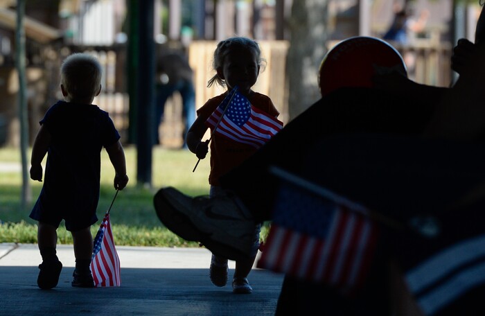 (Francisco Kjolseth | The Salt Lake Tribune) Young kids play with flags as their parents attend "Mondays With Mitt" at Veterans Memorial Park in West Jordan on Monday, June 18, 2018 where Senate candidate Mitt Romney visits with supporters and takes a few questions.