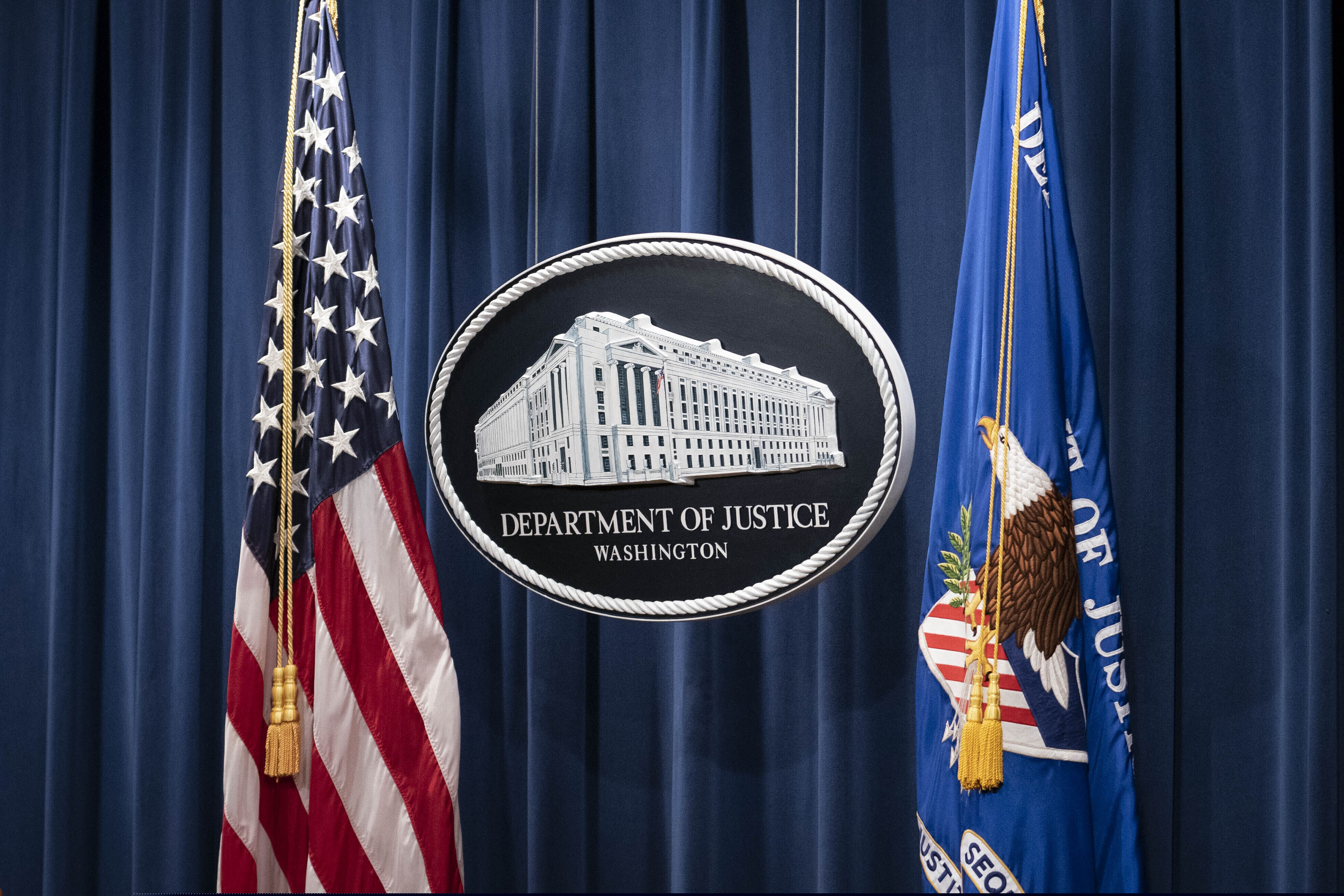 FILE - This Jan. 12, 2021, file photo shows a sign for the Department of Justice ahead of a news conference in Washington.  (Sarah Silbiger/Pool via AP, File)