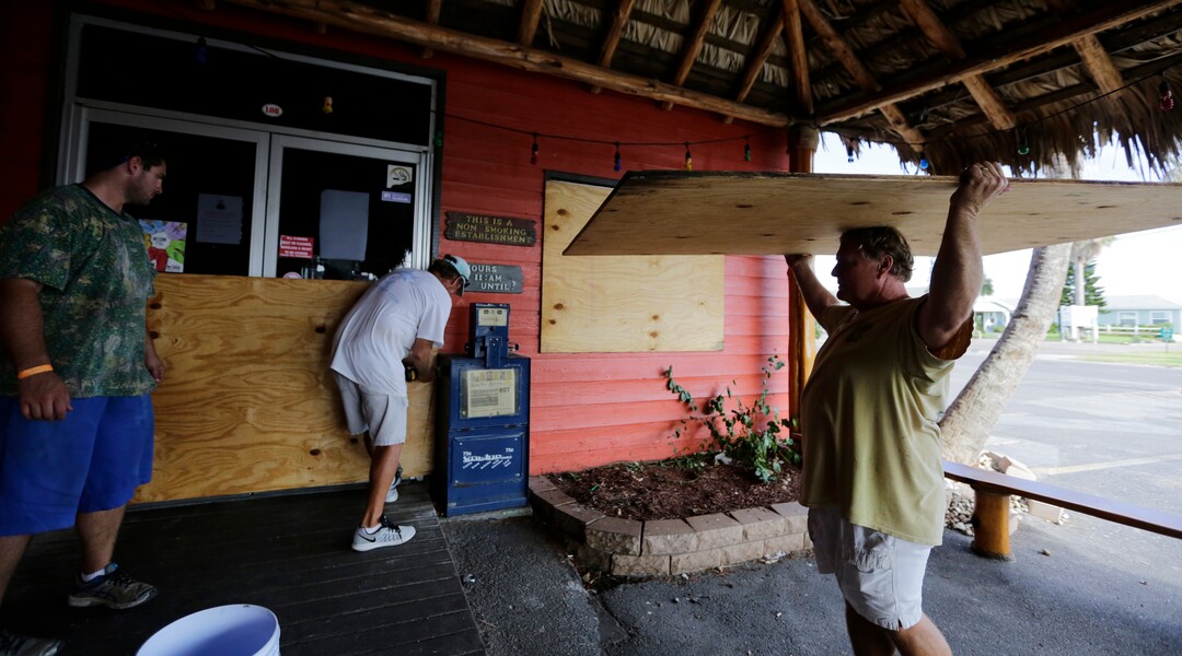 (Eric Gay | The Associated Press) Mac Owens, left, Mark Jones, center, and Kelly Owens, right, board up their business in preparation for Hurricane Harvey, Thursday, Aug. 24, 2017, in Port Aransas, Texas. Harvey intensified into a hurricane Thursday and steered for the Texas coast.